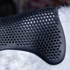 Close-up of a black grooming brush with a textured handle on a gray surface.